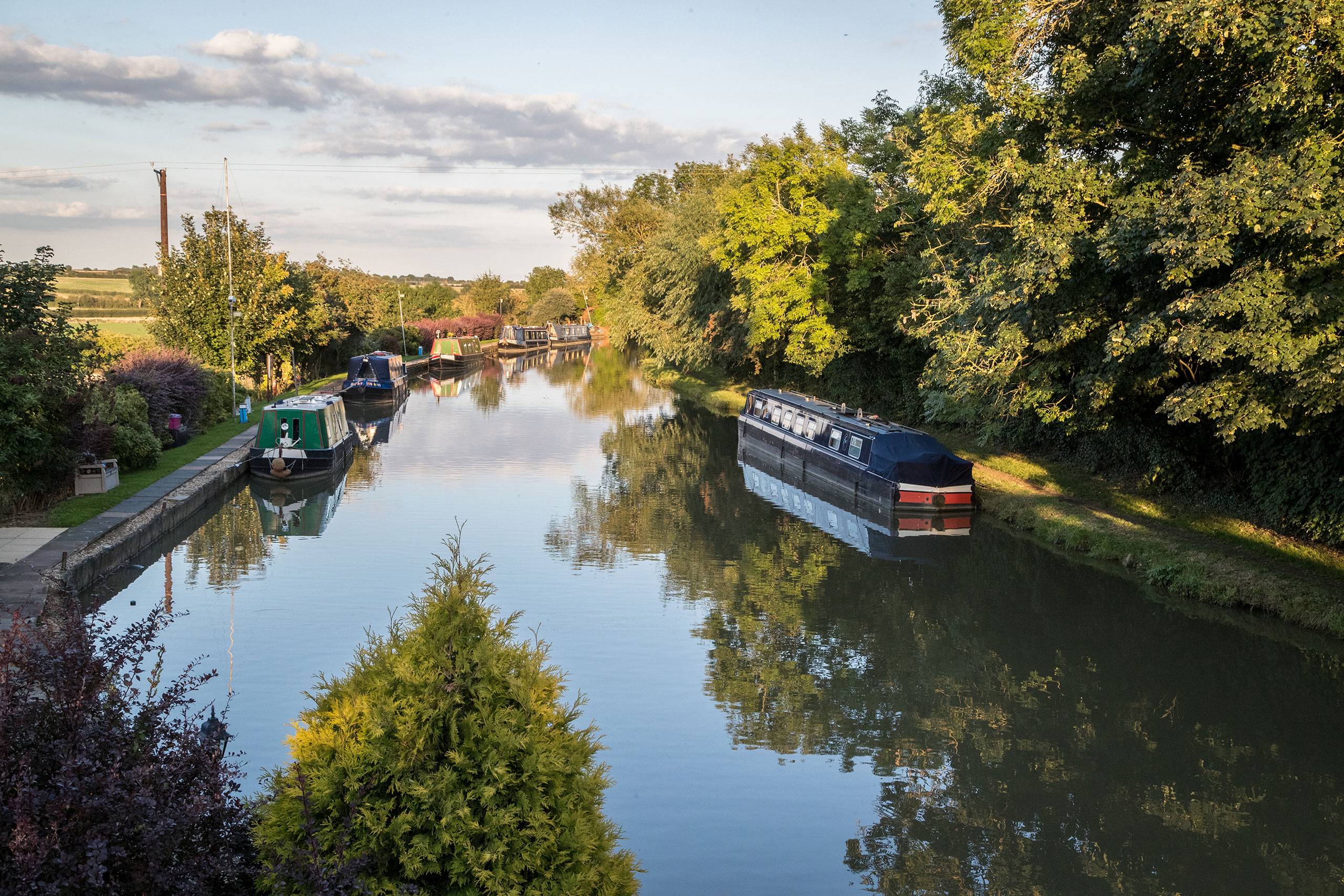 Several canal boats moored along the Grand Union Canal